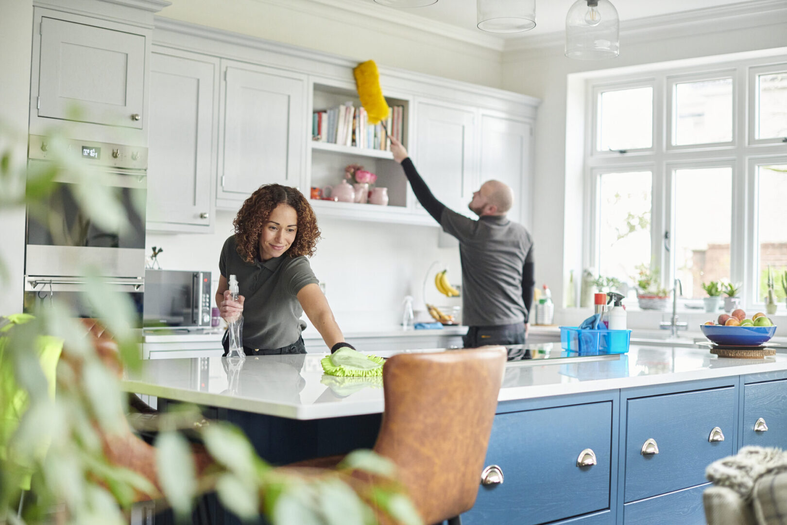 Man and woman tidying kitchen